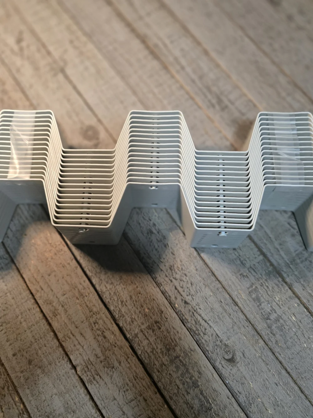 Stack of plastic honeycomb drawer divider panels in a light grey color.